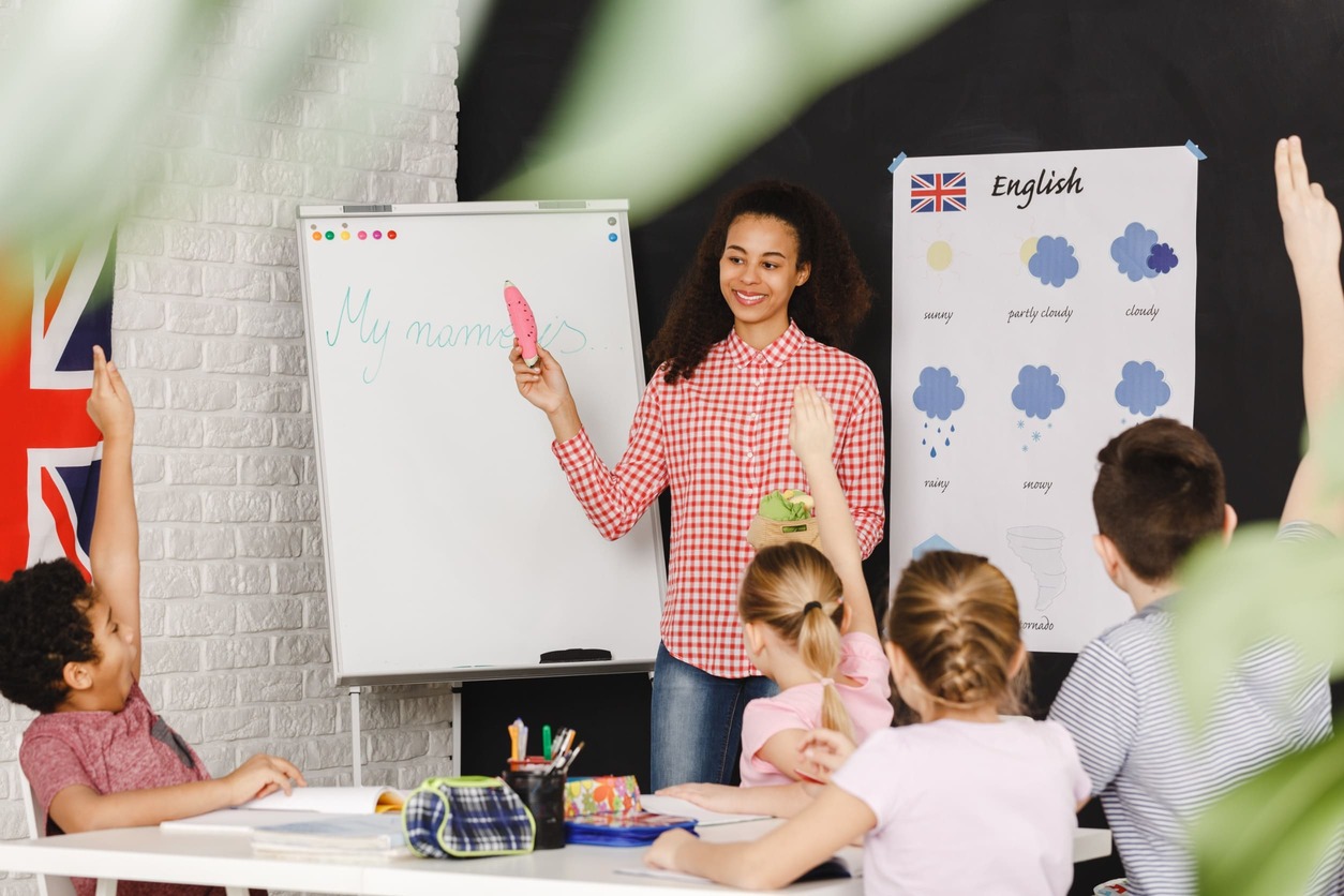 mujer dando clases de ingles a niños
